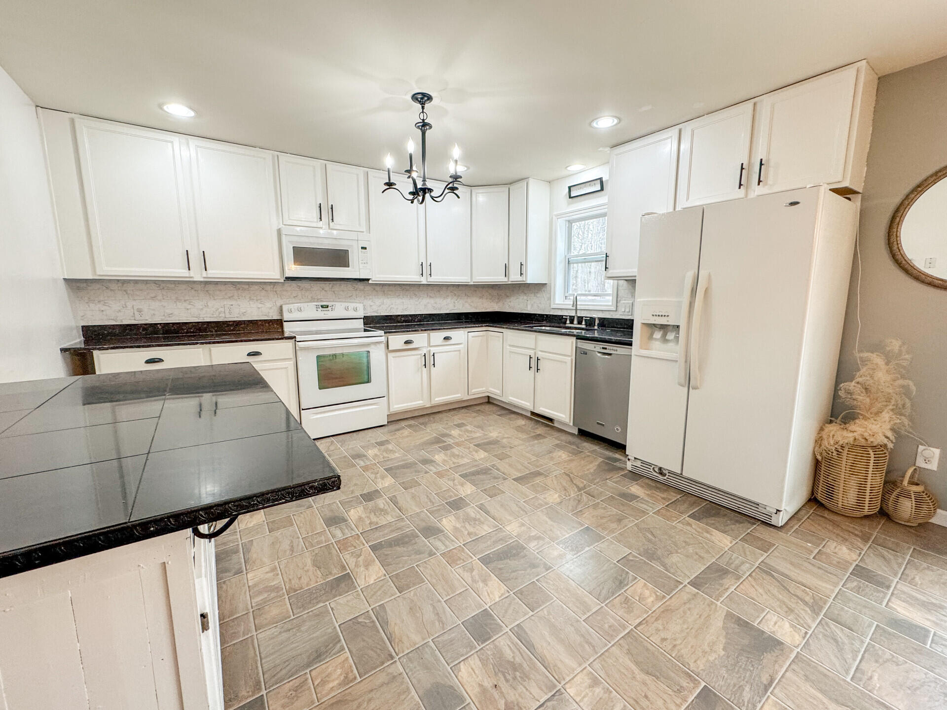 2236 Eagle Path Bushkill, PA 18324 - Photo 11 of 30 a kitchen with kitchen island granite countertop a stove a sink dishwasher a refrigerator and white cabinets with wooden floor