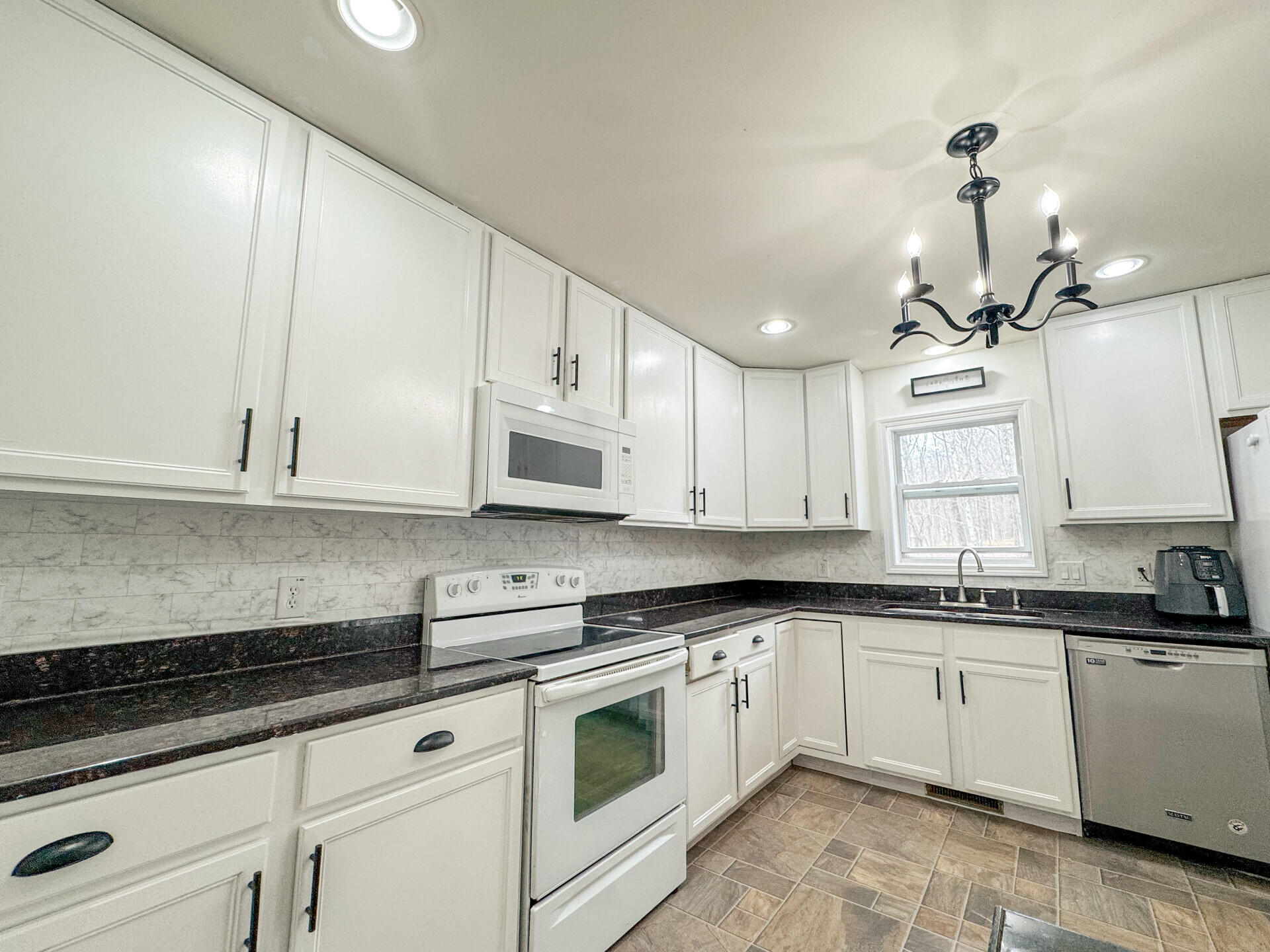 2236 Eagle Path Bushkill, PA 18324 - Photo 10 of 30 a white kitchen with granite countertop white cabinets and white appliances
