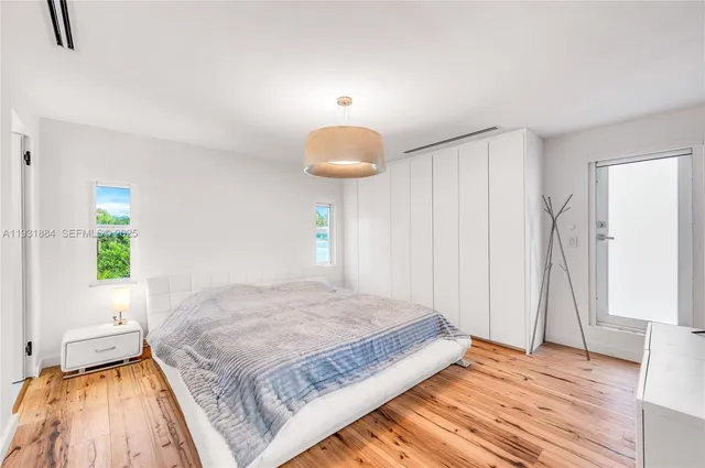 a bedroom with a bed mirror and window