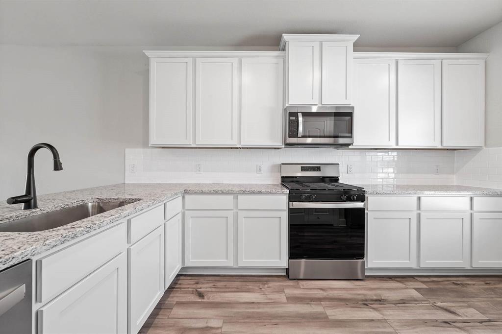 a kitchen with granite countertop a stove and a sink