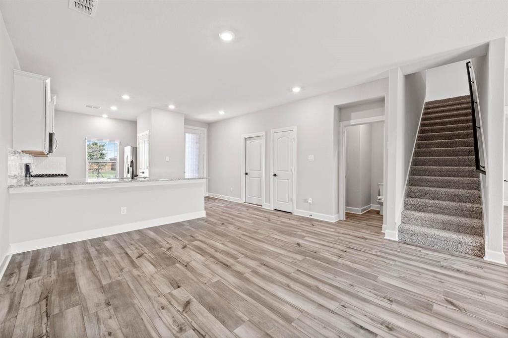809 Calhoun Drive Anna, TX 75409 - Photo 8 of 12 an empty room with wooden floor and windows