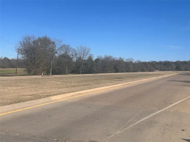 a view of a field with trees in background