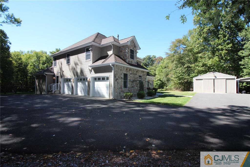 252 Deans Rhode Hall Road Monroe Township, NJ 08831 - Photo 3 of 25 a front view of a house with a yard and garage