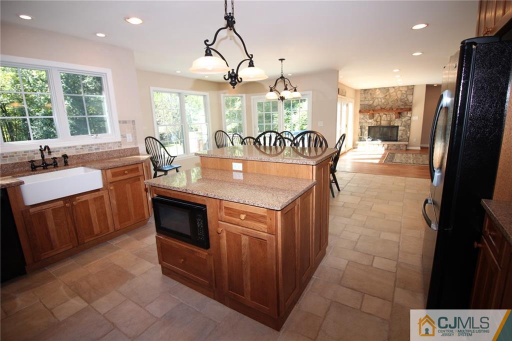252 Deans Rhode Hall Road Monroe Township, NJ 08831 - Photo 9 of 25 a kitchen with stainless steel appliances granite countertop a sink a stove a refrigerator and island