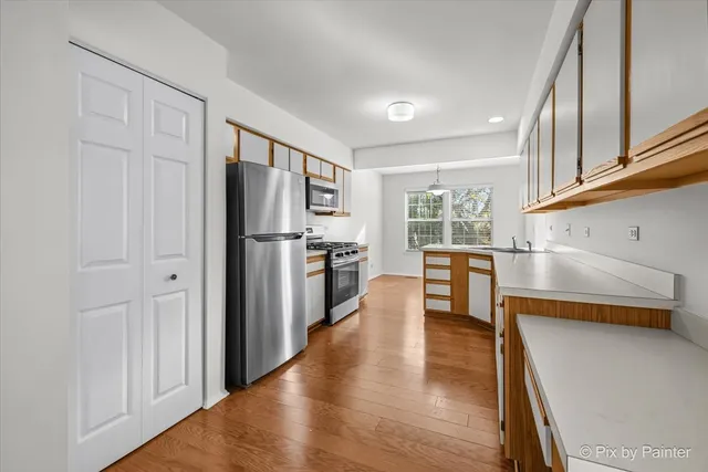 a kitchen with stainless steel appliances a refrigerator and wooden floor