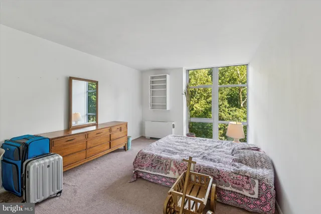 a bedroom with a bed chair and window