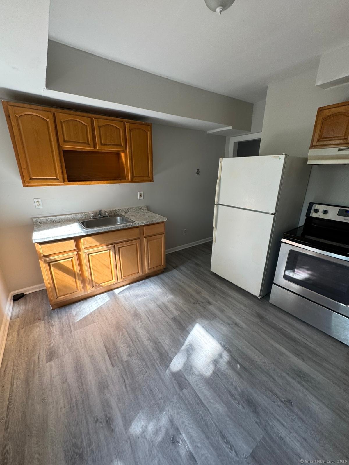1071 Pembroke Street, Unit 2E Bridgeport, CT 06608 - Photo 2 of 8 a view of a kitchen with wooden floor and electronic appliances
