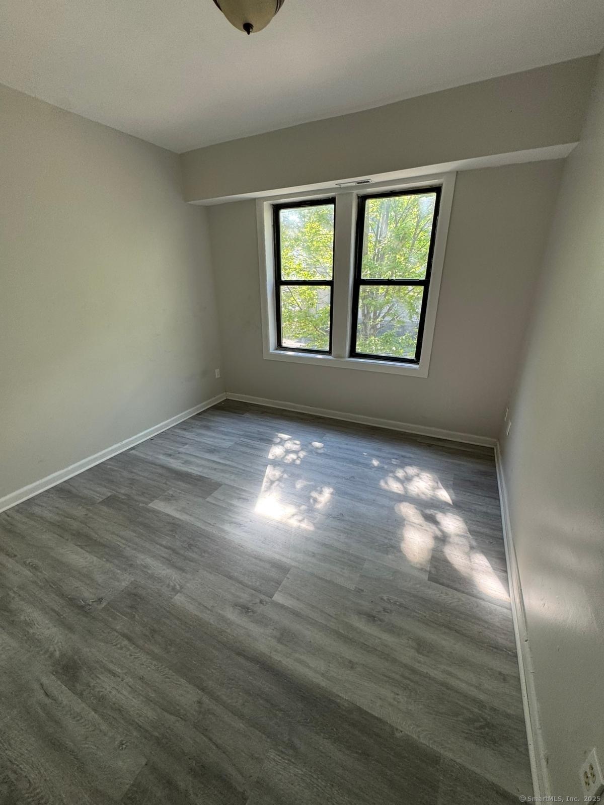 1071 Pembroke Street, Unit 2E Bridgeport, CT 06608 - Photo 4 of 8 wooden floor in an empty room with a window