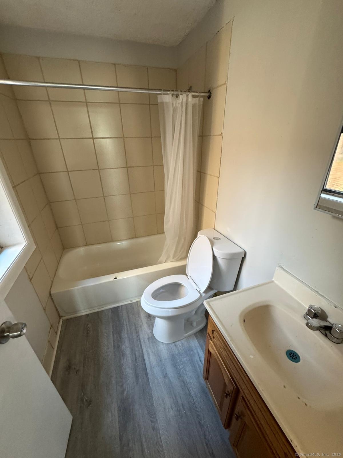 1071 Pembroke Street, Unit 2E Bridgeport, CT 06608 - Photo 6 of 8 a bathroom with a sink a toilet and shower