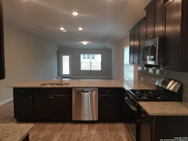 a kitchen with granite countertop a sink and cabinets
