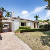 front view of a house with a yard and potted plants