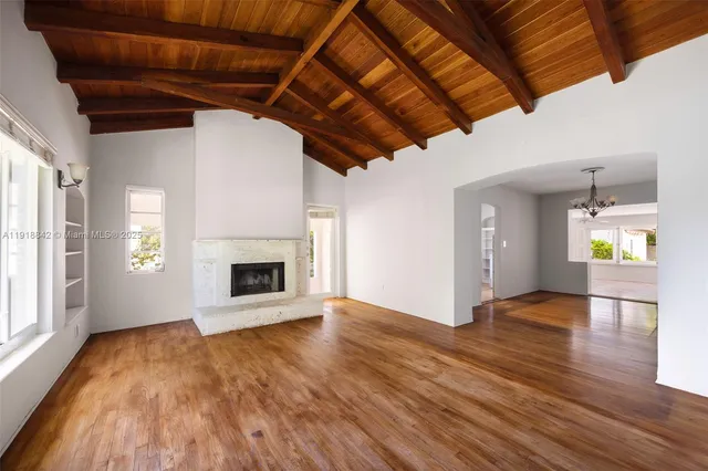 a view of empty room with wooden floor and fireplace