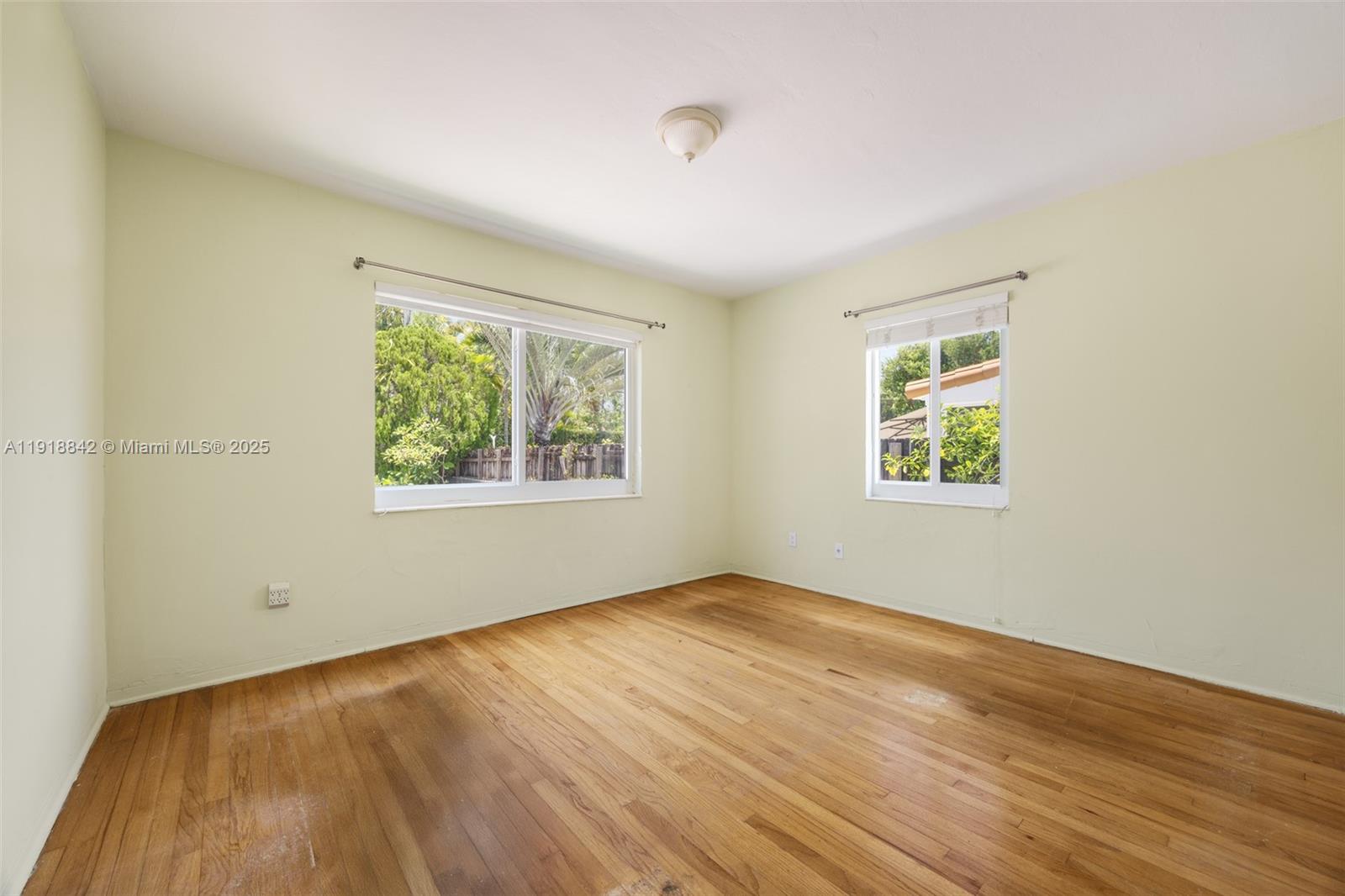 451 Southwest 25th Road, Unit 451 Miami, FL 33129 - Photo 7 of 10 an empty room with wooden floor and windows