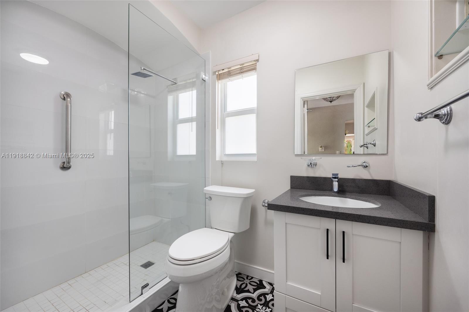 451 Southwest 25th Road, Unit 451 Miami, FL 33129 - Photo 8 of 10 a bathroom with a granite countertop sink toilet and shower