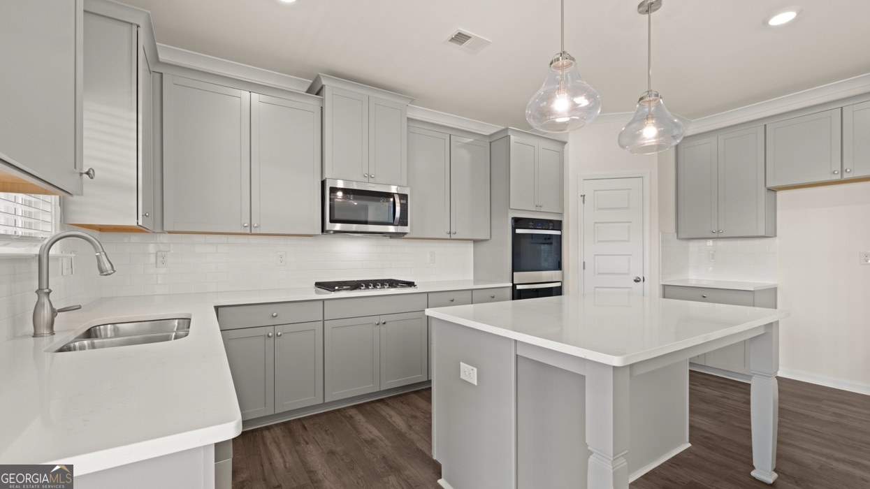 416 Hazel Drive Locust Grove, GA 30248 - Photo 11 of 31 a kitchen with kitchen island a sink appliances and cabinets