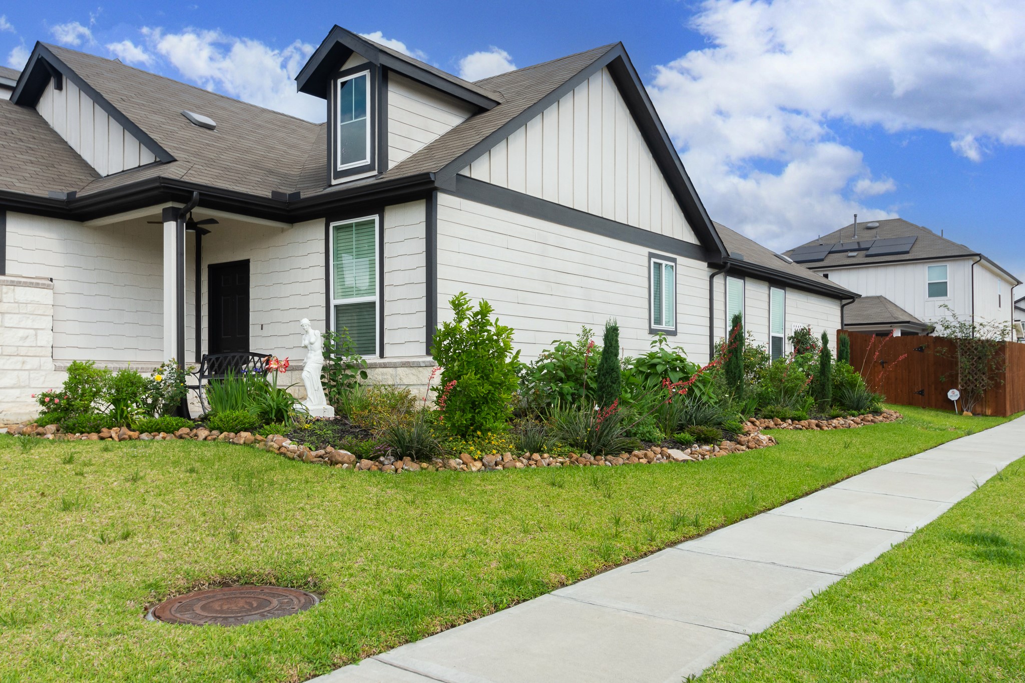 23502 Glenbuck St Spring Spring, TX 77373 - Photo 2 of 50 This modern home features a clean design with a well-maintained front yard and vibrant landscaping. Its light-colored exterior is accented with dark trim, offering a welcoming entrance and a spacious sidewalk leading up to it.
