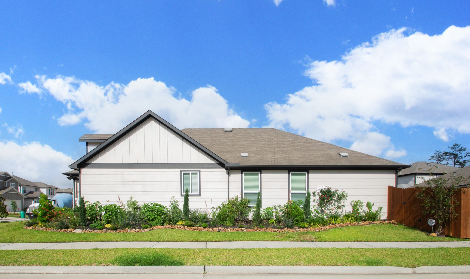 23502 Glenbuck St Spring Spring, TX 77373 - Photo 3 of 50 This photo shows a modern single-story home with a gable roof, light-colored siding, and well-maintained landscaping. The property features a fenced yard and is located in a suburban neighborhood.