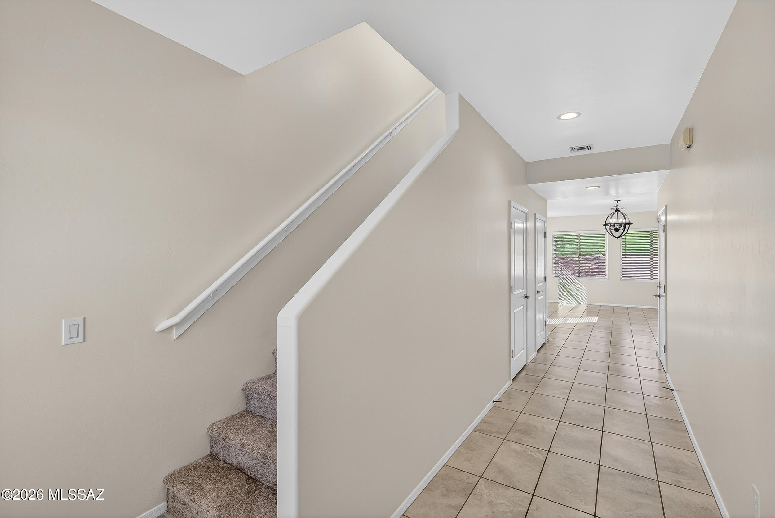 7556 South Circulo Rio Blanco Tucson, AZ 85756 - Photo 4 of 50 Welcoming foyer with elegant staircase featuring brand new plush carpeted steps and a clean white handrail. The bright, open design with neutral tones, creates a warm first impression as you enter the home.