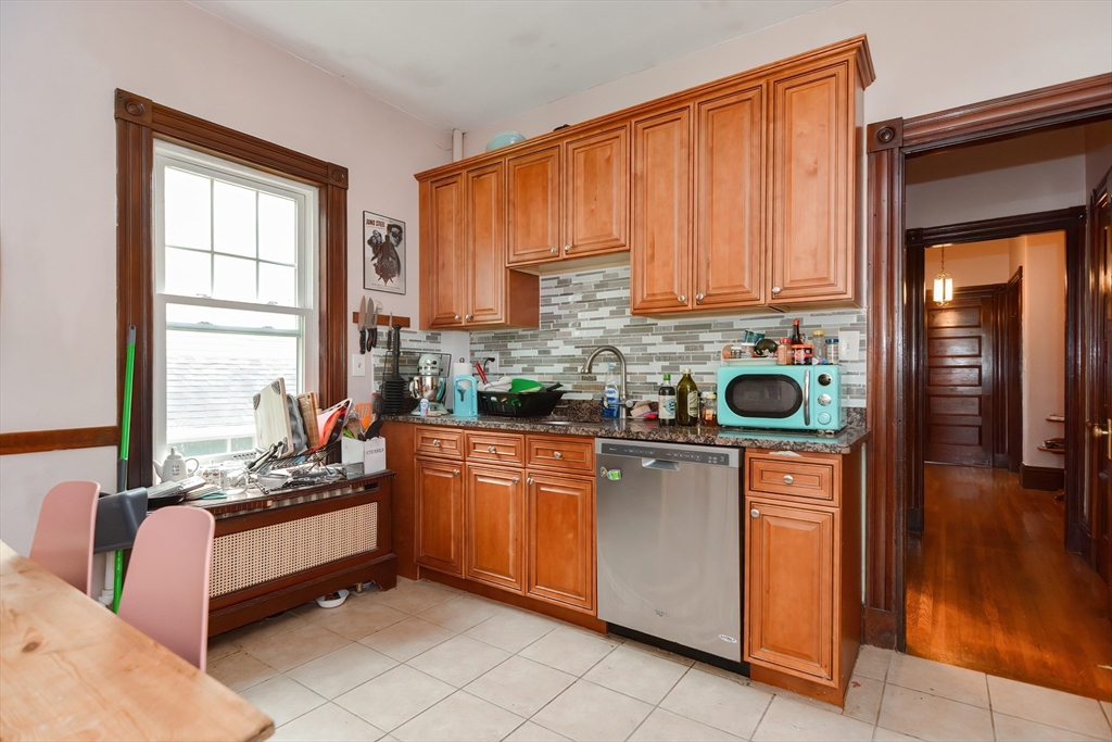 52 Tower Street Boston, MA 02130 - Photo 17 of 29 a kitchen with stainless steel appliances granite countertop a stove a sink and a refrigerator