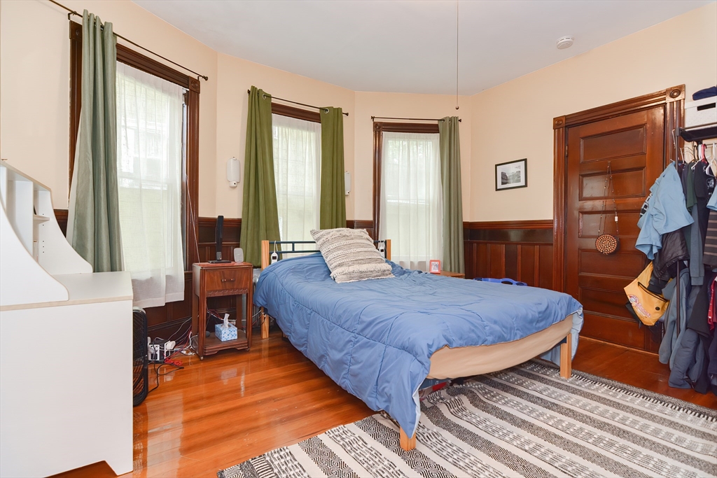 52 Tower Street Boston, MA 02130 - Photo 4 of 29 a bedroom with a bed and wooden floor