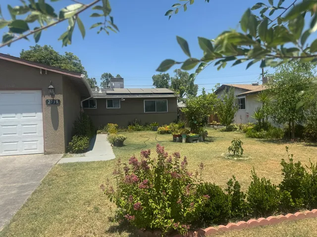a view of a house with pool plants and large trees