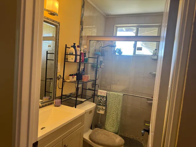 a bathroom with a granite countertop sink toilet and shower