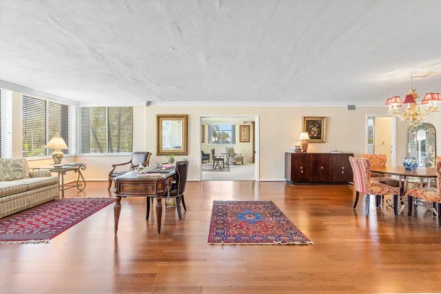 a living room with furniture a rug a flat screen tv and a table