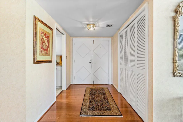 a view of a dining room and livingroom with furniture wooden floor a chandelier