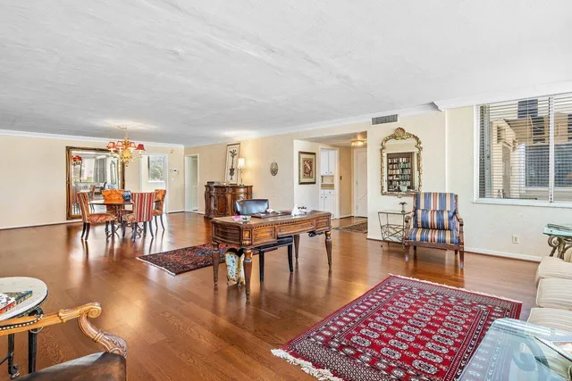 a living room with furniture a rug a lamp and a large window
