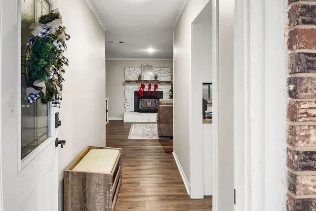 a view of a hallway with wooden floor and a potted plant