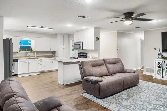 a living room with furniture and kitchen view