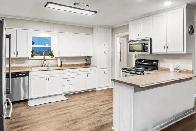 a kitchen with a sink stove and white cabinets