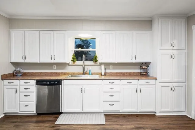 a kitchen with granite countertop a sink cabinets and stainless steel appliances