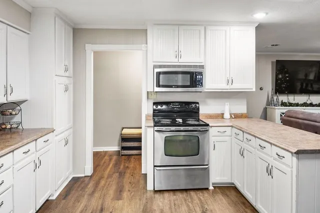 a kitchen with stainless steel appliances granite countertop a stove a sink and a microwave