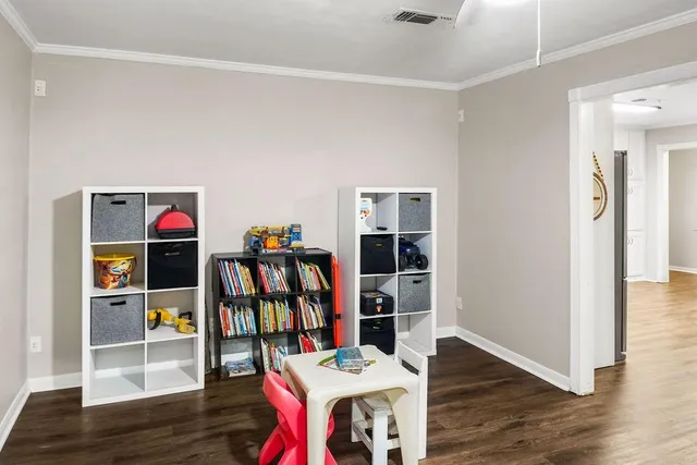 a living room with lots of books and a wooden floor
