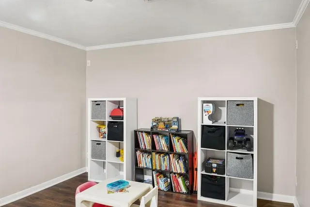 a living room with lots of books and a shelf