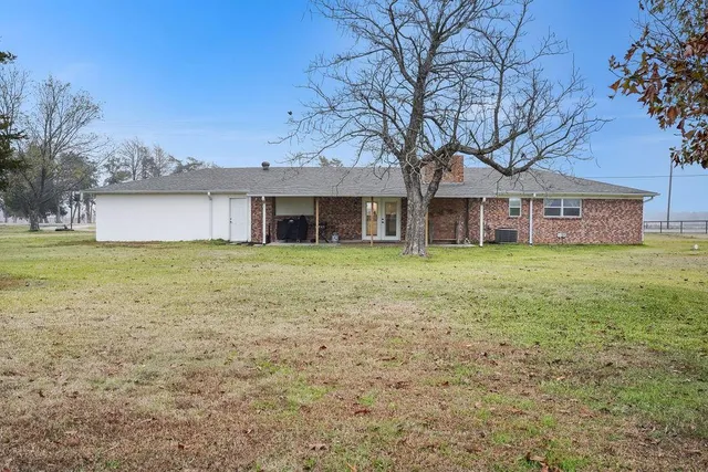 a view of a house with a yard and trees