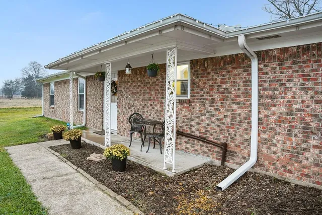 a view of a patio with a table and chairs and potted plants with wooden fence