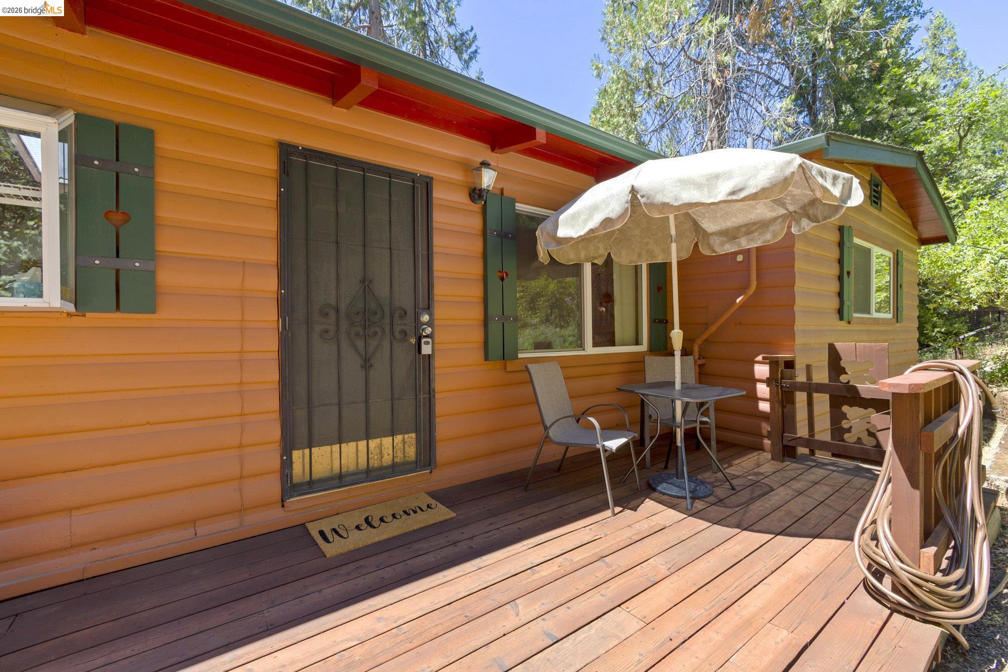 21815 Confidence Road Twain Harte, CA 95383 - Photo 27 of 30 a view of a patio with table and chairs with wooden floor and fence
