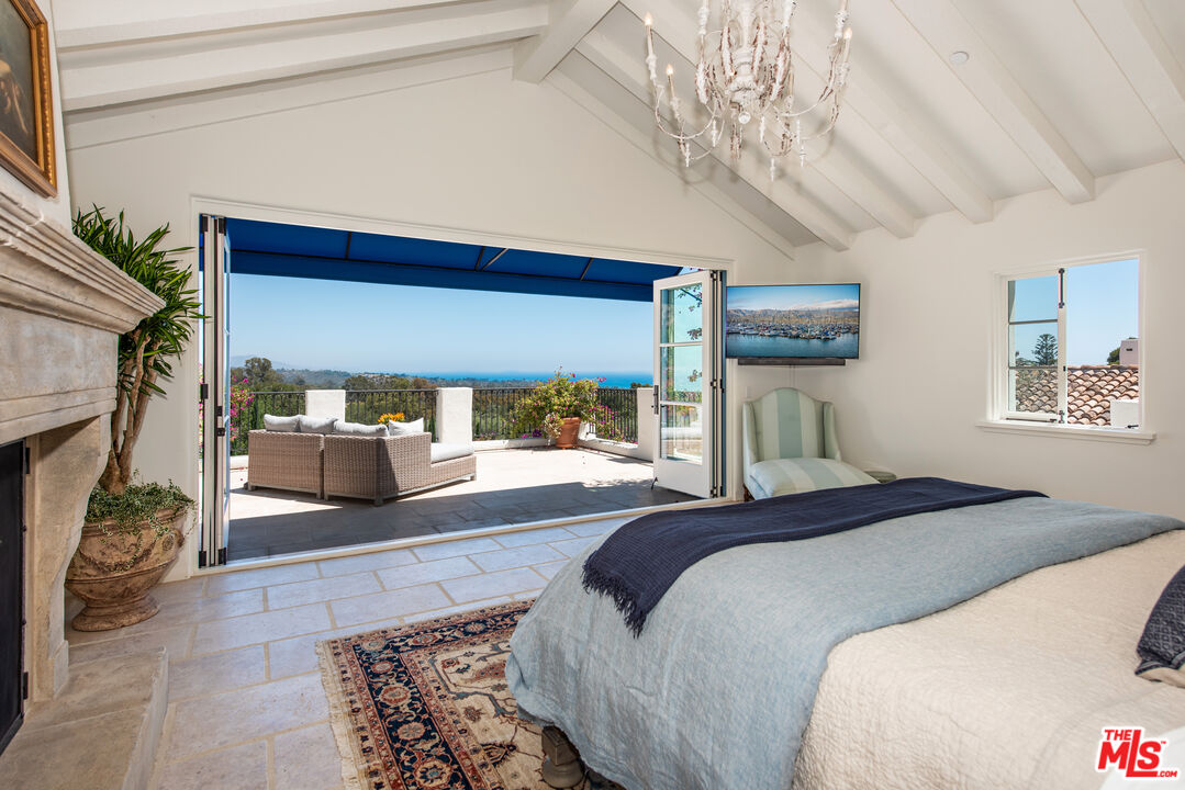848 Picacho Lane Montecito, CA 93108 - Photo 13 of 22 a bedroom with a large bed and a chandelier