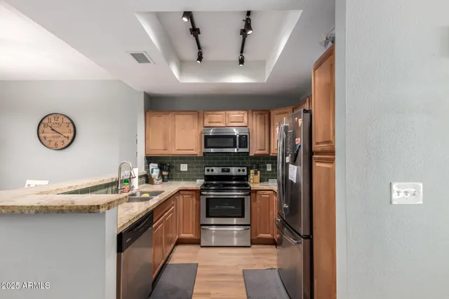 a kitchen with stainless steel appliances granite countertop a stove and a refrigerator