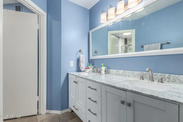 a bathroom with a granite countertop sink and a mirror