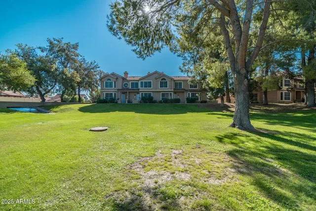 a view of a big yard with a house and large trees
