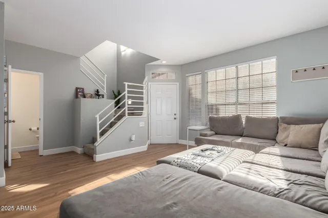 a living room with furniture and stairs