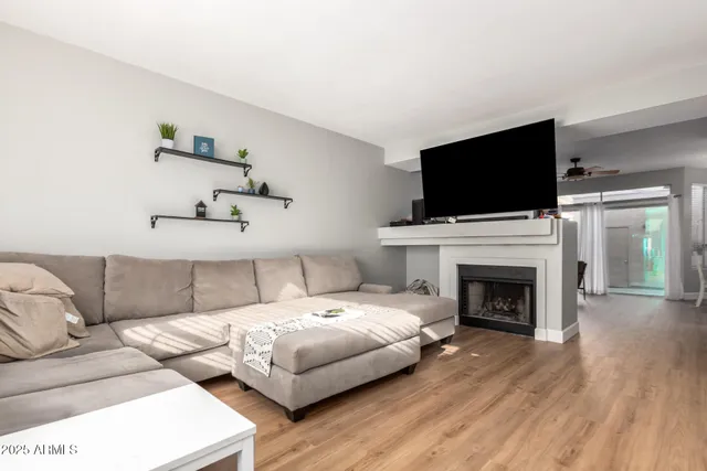 a living room with furniture a flat screen tv and a fireplace