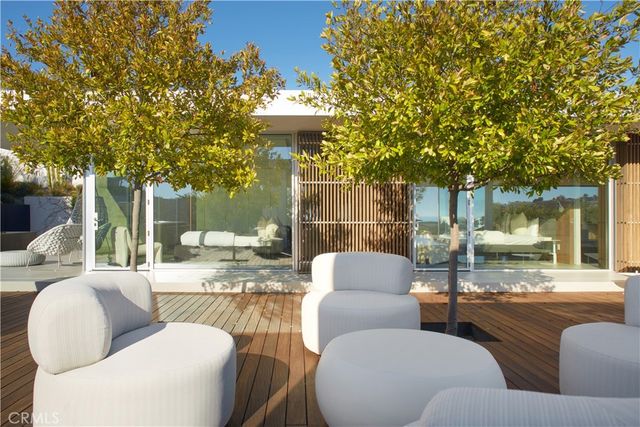a view of a patio with couches and a table and chairs with wooden fence