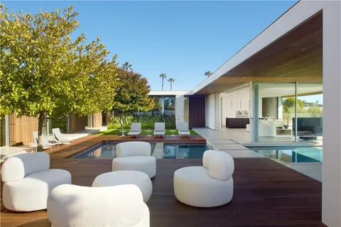 a living room with patio furniture and a large tree