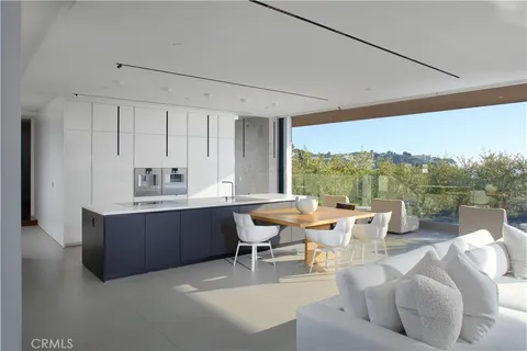 a living room with furniture a large window and a sink