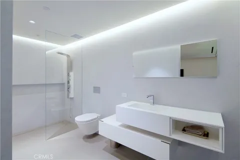 a bathroom with a sink a toilet and a mirror