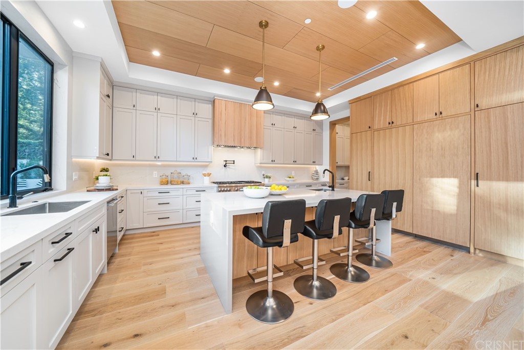 11201 Valley Spring Lane Studio City, CA 91602 - Photo 5 of 14 a large kitchen with kitchen island granite countertop a stove a sink a dining table and chairs